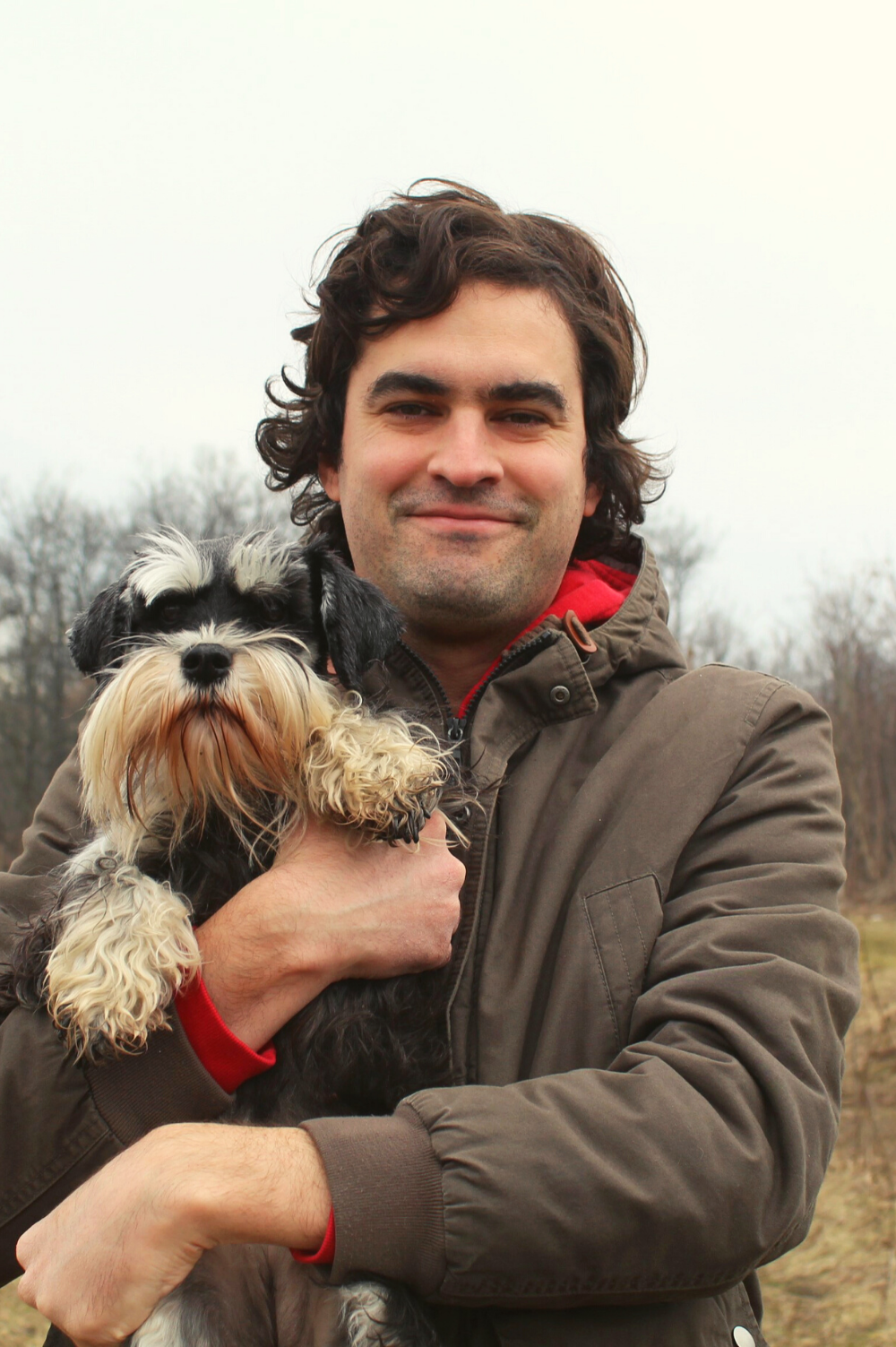 Portret muške osobe koja drži psa.